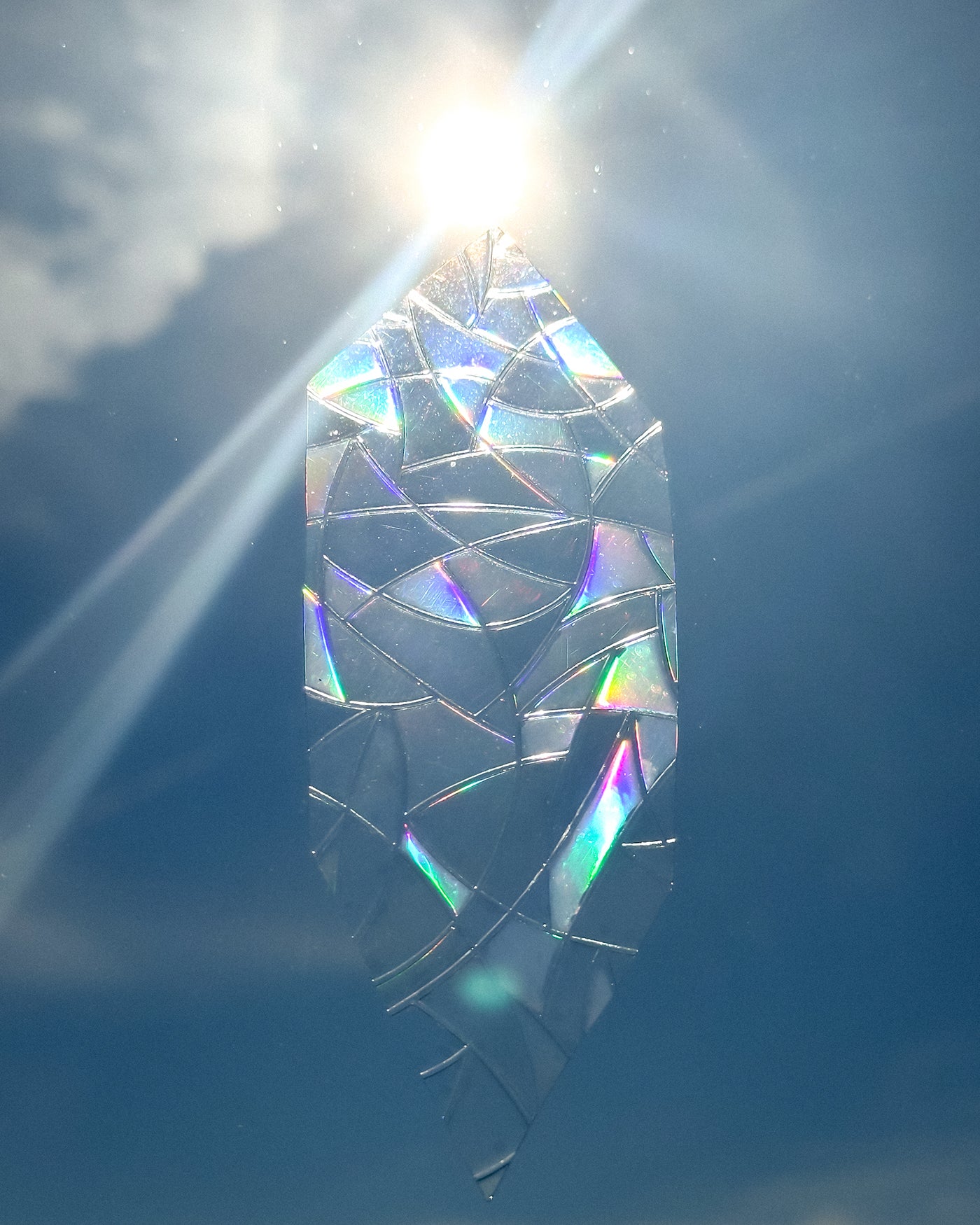 Iridescent glass decoration on a window with sunlight shining through