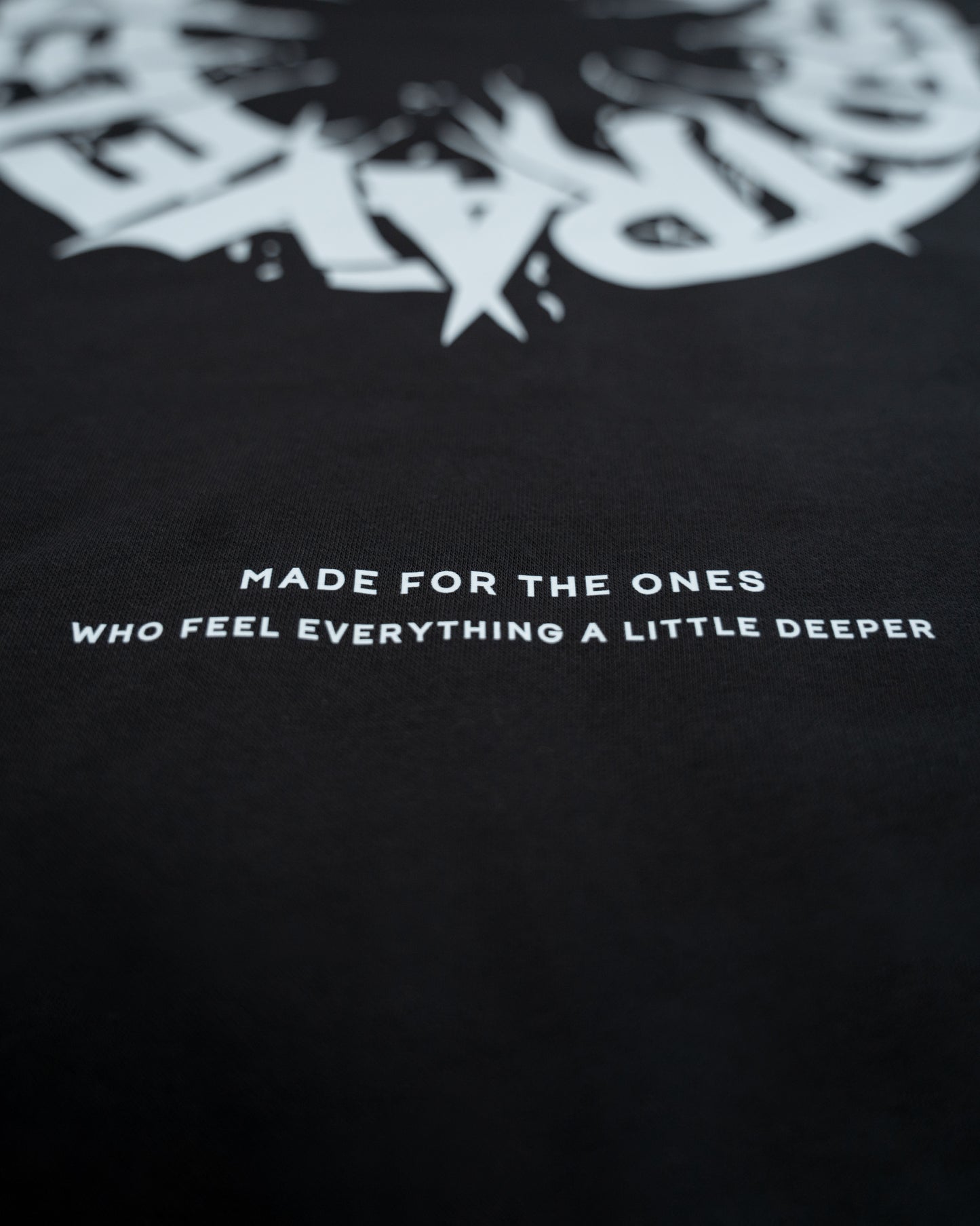 Black t-shirt with white text and logo design on a dark background